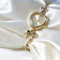 Heart Case Bracelet Watch — Gold-Tone, Crystal Bezel, Champagne Dial & Bow Charm Chain, Women